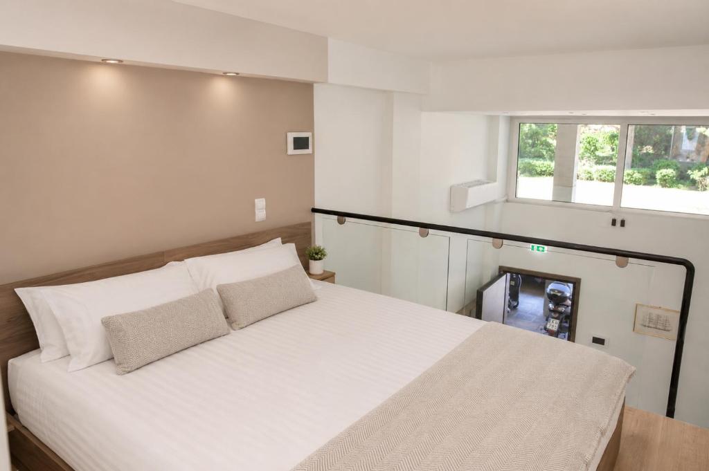 The mezzanine bedroom with a double bed beside the glass balustrade and a garden-facing window