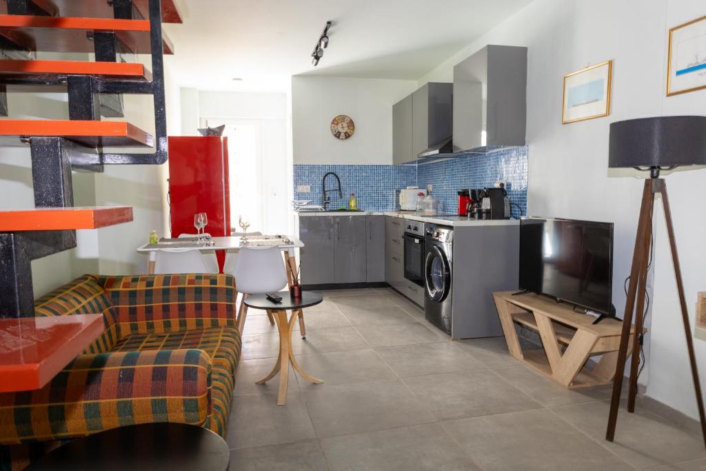 The open-plan living area and kitchen, with the checked sofa and the staircase to the mezzanine