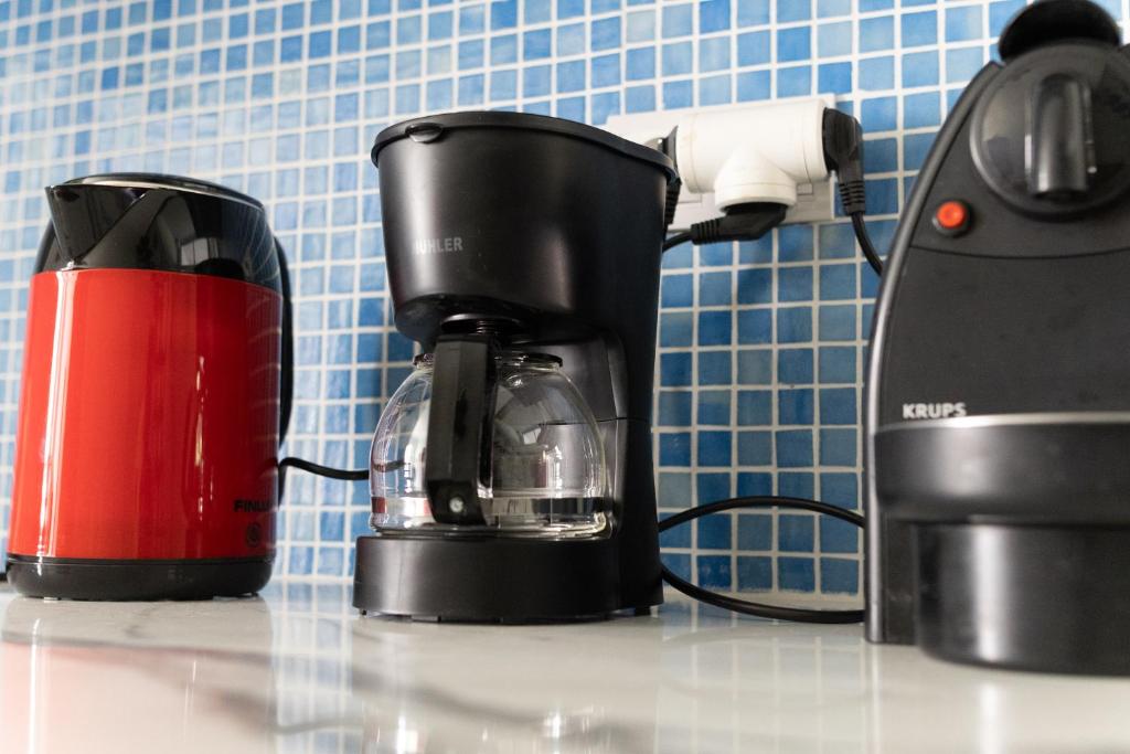 The coffee corner against the blue-tiled splashback: kettle, filter machine and espresso maker